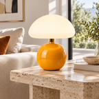 Lámpara hongo naranja sobre mesa de travertino en sala luminosa de día