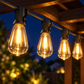 Focos de la guirnalda solar encendidos colgando de una pérgola de madera de noche
