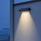 Luz solar para barda encendida en muro blanco minimalista al anochecer