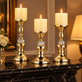 Candelabros dorados con cristal y velas sobre chimenea de mármol negro